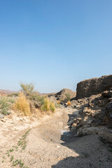 Dry riverbed in the Hajar Mountains of the United Arab Emirates with clear blue sky, UAE, desert landscape with copy space