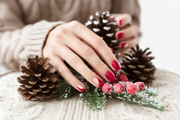 Female hands with viva magenta manicure and gold foil on the nails. Winter and Christmas time...