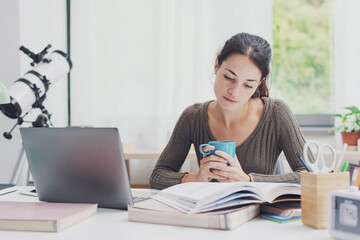 Student doing homework and drinking coffee