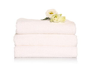 Obraz na płótnie Canvas Folded soft terry towels with beautiful flowers on white background