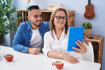 Man and woman mother and son drinking coffee having video call at home