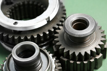 Different stainless steel gears on light green background, closeup