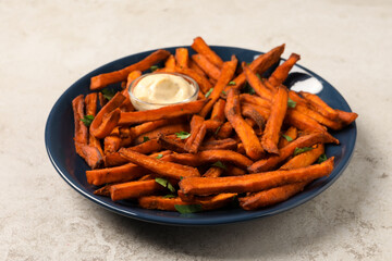 Delicious sweet potato fries served with sauce on light table