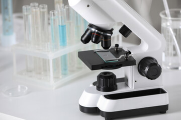 Modern medical microscope on white table in laboratory, closeup. Space for text
