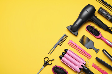 Fototapeta na wymiar Flat lay composition of professional hairdresser tools on orange background, space for text