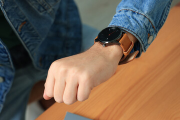 Man checking time in room, closeup. Being late