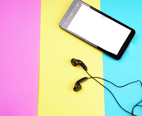 Top view of Mobile phone with headphones isolated on colorful background, Listen to music. Space for text