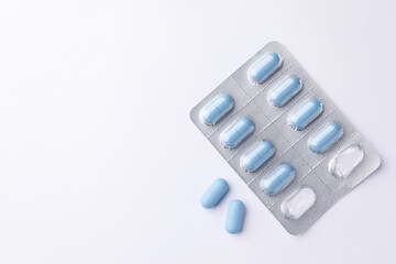 Pills and space for text on white background, top view. Potency problem