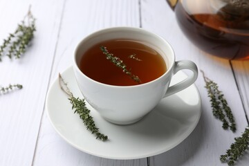 Aromatic herbal tea with thyme on white wooden table