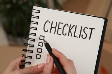 Woman filling Checklist with pen indoors, closeup