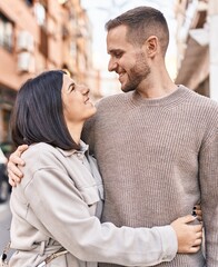 Man and woman couple smiling confident hugging each other standing at street