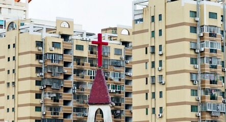 Church cross on the background of city apartment buildings