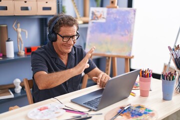 Middle age man artist smiling confident having video call at art studio