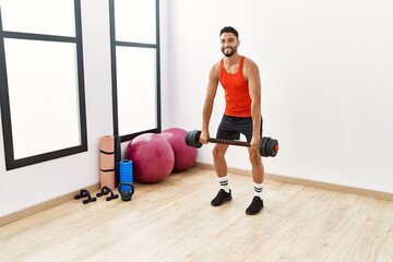 Obraz premium Young arab man smiling confident training with dumbbells at sport center