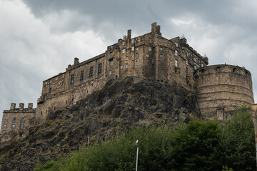 Fototapeta na wymiar Edinburgh castle up high on castle rock overlooking the city from its arial vantage point. This historic building is an exceptionally popular tourist attraction for visitors from all over the world