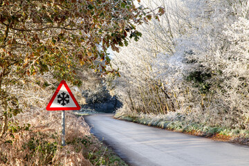 Frosty rural road and snowflake warning sign Norfolk