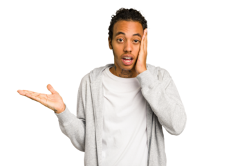 Young African American man isolated impressed holding copy space on palm.