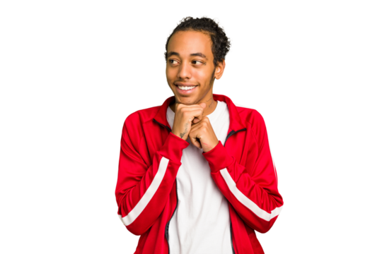 Young African American man isolated keeps hands under chin, is looking happily aside.