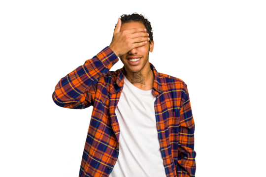 Young African American man isolated covers eyes with hands, smiles broadly waiting for a surprise.