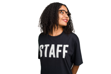 Young african american staff woman isolated looks aside smiling, cheerful and pleasant.