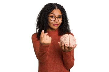 Young student african american woman holding a brain isolated pointing with finger at you as if inviting come closer.