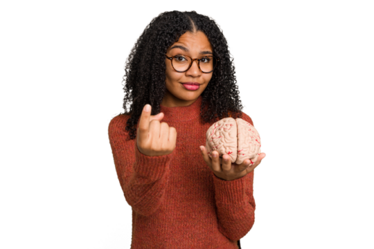 Young student african american woman holding a brain isolated pointing with finger at you as if inviting come closer.