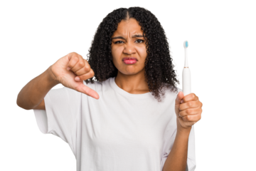 Young african american using a brushing teeth isolated showing a dislike gesture, thumbs down. Disagreement concept.