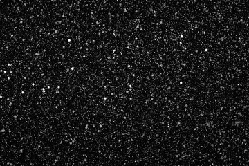 an abstract black background with shniy dots. close up on paper with glitter. a black and white background with wihte dots