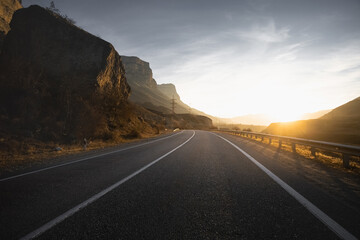 Empty road in mountains at sunset