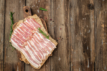 Smoked bacon strips meat slice thin slicing pork fat meal on a wooden background, ketogenic diet, place for text, top view