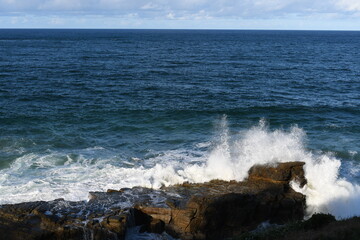 Huge waves crush on rock island and make beutiful splashes at  Yamba Lighthouse area, NSW, Australia