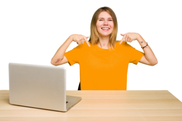 Young caucasian woman in a workplace working with a laptop isolated points down with fingers, positive feeling.