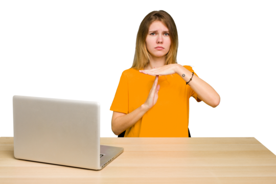 Young caucasian woman in a workplace working with a laptop isolated showing a timeout gesture.