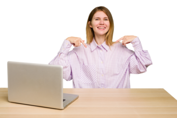 Young caucasian woman in a workplace working with a laptop isolated points down with fingers, positive feeling.