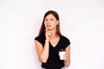 Portrait of incredulous young woman holding coffee over white background. Caucasian lady wearing...