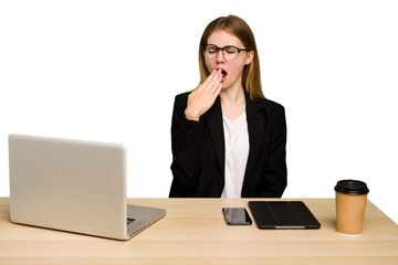 Young business caucasian woman working on her workplace cutout isolated yawning showing a tired...