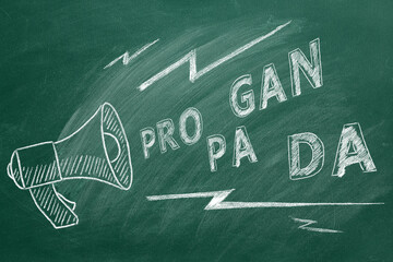 Propaganda and fake news concept. Illustration on greenboard. A megaphone with the word propaganda. Misinformation and counterinformation concept.
