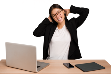 Young business asian woman sitting on a table isolated stretching arms, relaxed position.