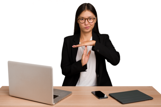 Young business asian woman sitting on a table isolated showing a timeout gesture.