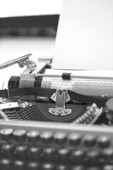 Vintage Typewriter machine with a sheet of paper and generic text typed, closeup black and white photo