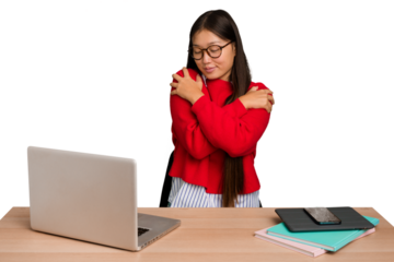 Young student asian woman in a workplace with a laptop isolated hugs, smiling carefree and happy.