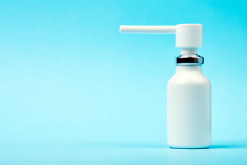 Nasal spray bottle on blue background with copy space