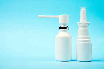Nasal spray bottle on blue background with copy space