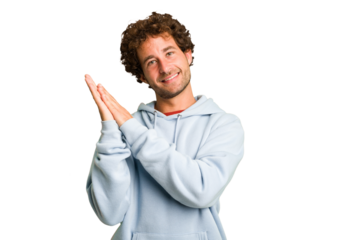 Young curly smart caucasian man cut out isolated feeling energetic and comfortable, rubbing hands confident.