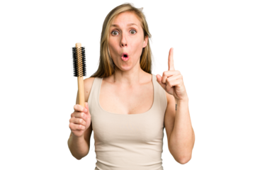 Young caucasian woman using an hair comb isolated having some great idea, concept of creativity.