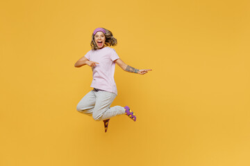 Fototapeta na wymiar Full body young woman she wears purple pyjamas jam sleep eye mask rest relax at home jump high point finger aside on area mock up isolated on plain yellow background studio portrait Night nap concept