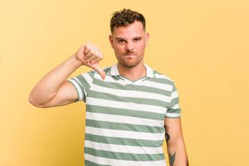 Obraz premium Young caucasian handsome man isolated on yellow background showing thumb down, disappointment concept.