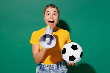 Young woman fan wears basic yellow t-shirt cheer up support football sport team hold in hand soccer...