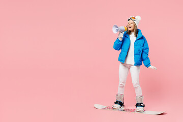 Snowboarder woman wearing blue suit goggles mask hat ski padded jacket hold scream aside in...