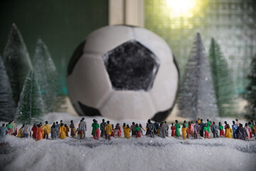 World cup at wintertime concept. Football (Soccer) ball on snowy decorated table with toy...